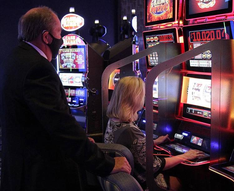 Prosecuting Attorney Kyle Hunter watches as his wife, Tina, racks up points on one of the new progressive slot machines at Saracen Casino. When the photo was taken, Tina Hunter was up to around $1,250 on the machine. “She started out with $100,” Kyle said. “If she hits the double jackpot, we’re out of here.” (Pine Bluff Commercial/Dale Ellis)